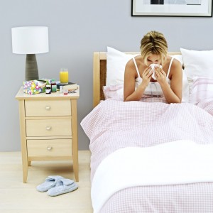 Young Woman Blowing Her Nose in Bed